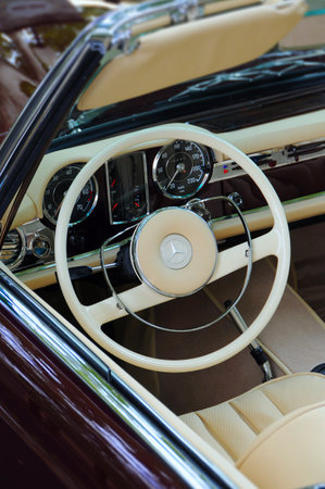 Detail of a vintage car interior with steering wheel and dashboard.
