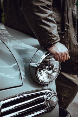 Close-up of a man's hand on the headlight of a carの写真素材