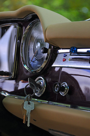 A closeup shot of the dashboard of a vintage car with keys