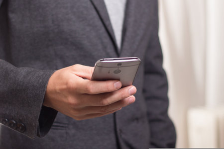 Businessman using mobile smart phone in office. Closeup shot.の写真素材