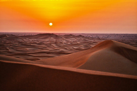 Sunset in the desert with sand dunes in Dubai, United Arab Emiratesの写真素材