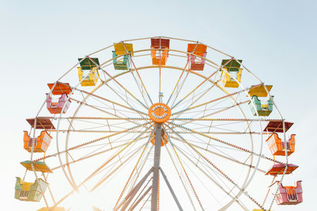 Ferris wheel in the amusement park on blue sky background, vintage style