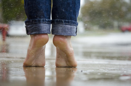 Wet woman's legs in jeans on a rainy dayの写真素材