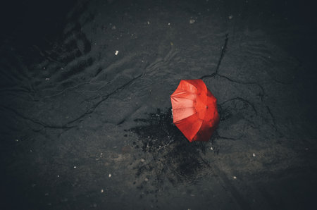 Red paper umbrella floating on the water in the rain, vintage toneの写真素材