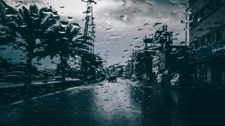 Raindrops on the windshield of a car, in the city.の写真素材