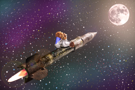 Monkey mascot toy in rocket flying to the moon  の写真素材