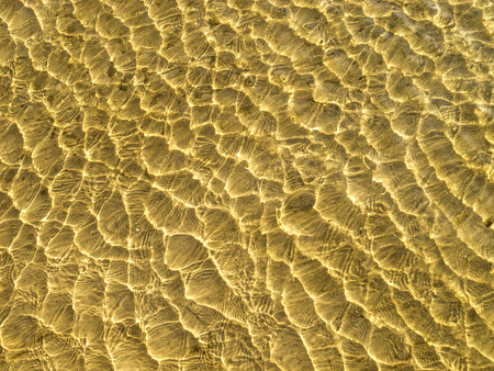 Yellow sand waves in shallow water  の写真素材