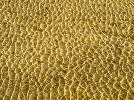 Yellow sand waves in shallow water  の写真素材