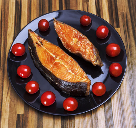 Smoked fish on plate with fresh tomatoesの写真素材