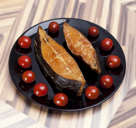 Smoked fish on plate with fresh tomatoesの写真素材