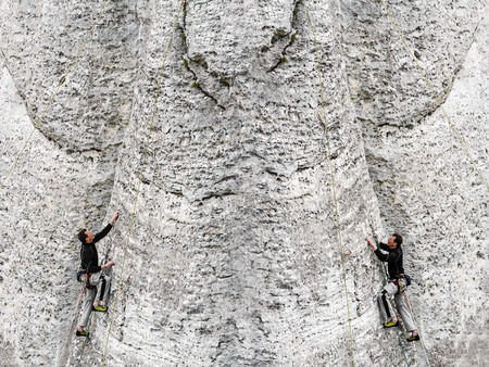 Concept of the same man climbing rocky mountain from both direction の写真素材