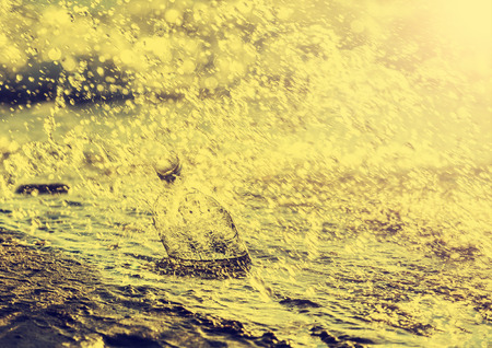 Bottle with water drops on beach の写真素材
