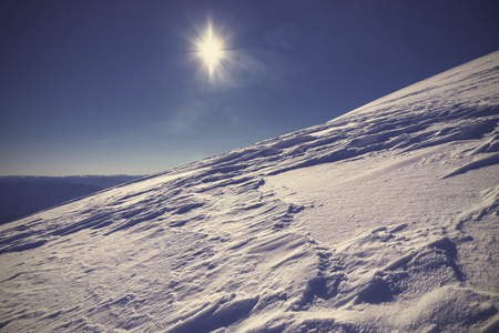 Winter mountain covered with snow against the sun, picture in retro style の写真素材
