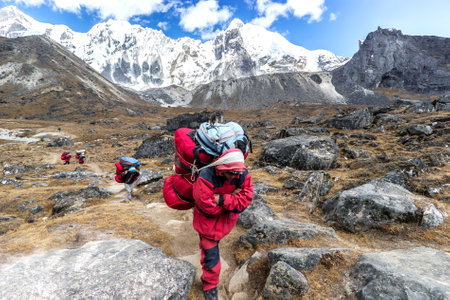 Cho La Pass, Nepal - October 18, 2011: Porters with heavy load after crossing Cho La Pass in Himalayas, located 5,420 meters (17,782 ft) above sea level in Solukhumbu District in northeastern Nepal.のeditorial素材
