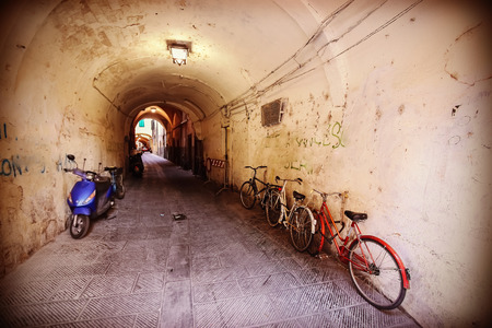 Retro filtered picture of neglected passage with bikes.の写真素材