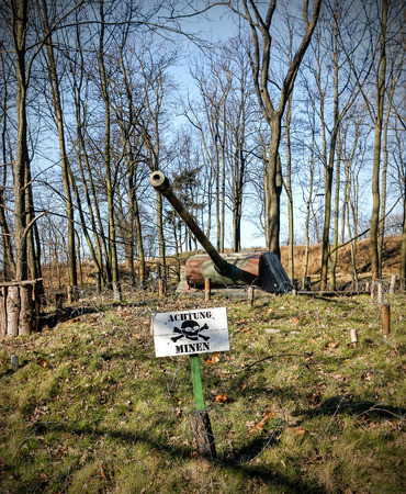 Land mine warning sign and barrel of a tank.の写真素材