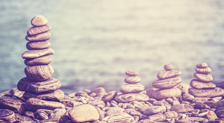 Vintage retro hipster style image of stones on beach, spa concept background.の写真素材