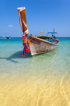 Wooden boat on crystal clear shallow water, Railay Beach.の写真素材