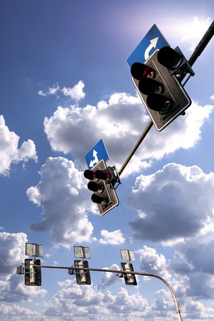 Traffic lights against a vibrant blue sky with clouds.の写真素材