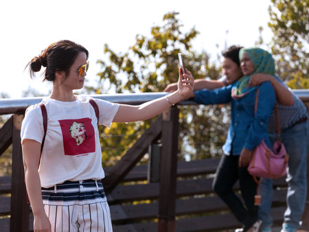 Langkawi, Malaysia - January 13, 2015: Tourist taking selfie pictures on the top of Langkawi Cable Car view point at sunset.のeditorial素材