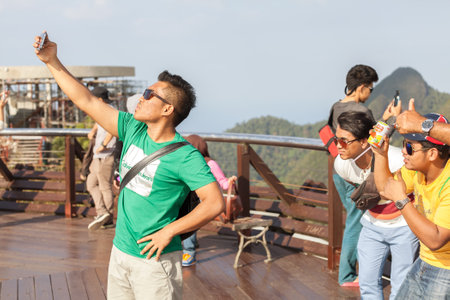 Langkawi, Malaysia - January 13, 2015: Tourists taking selfie pictures on the top of Langkawi Cable Car view point at sunset.のeditorial素材