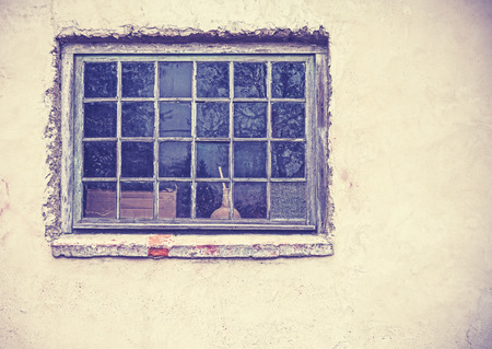 Old grungy window on an old dirty wall, retro filtered.の写真素材