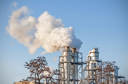 Smoking chimneys over blue sky, air pollution concept.の写真素材