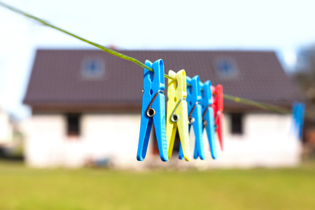 Clothespins hanging on a cord in front of house, concept photo.の写真素材