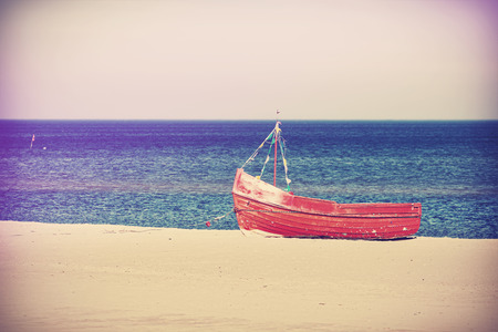 Vintage filtered photo of an old abandoned boat on the beach.の写真素材