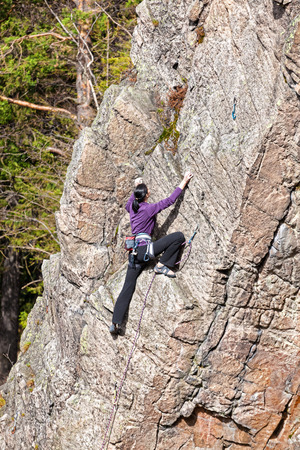 Female rock climber on a steep cliff.の写真素材