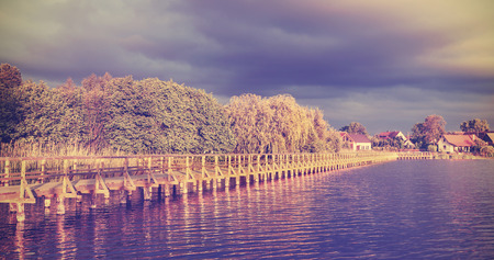 Vintage toned long wooden pier at sunset.の写真素材
