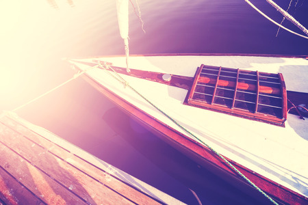 Vintage style photo of a sailing boat at sunset.の写真素材