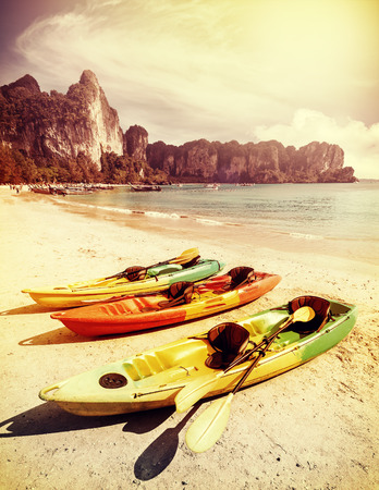 Retro toned kayaks on a tropical beach. Active holidays background.の写真素材