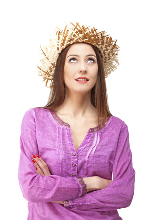 Young woman looking up wearing summer clothes with straw hat.の写真素材