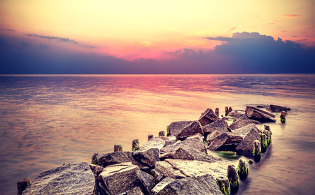 Purple sunset over beach, peaceful sea landscape.の写真素材