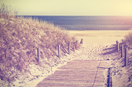 Retro toned photo of a beach path, old film filter applied.の写真素材