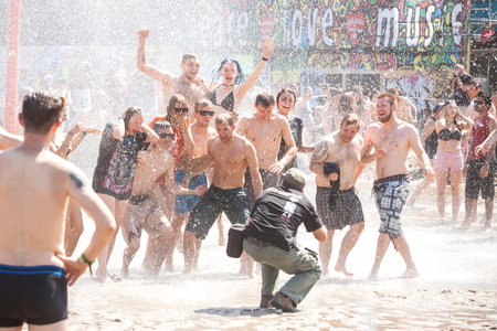 Kostrzyn nad Odra, Poland - August 1, 2015: Photographer taking picture of people playing in mud during 21th Woodstock Festival Poland (Przystanek Woodstock), one of the biggest view open air festival's in Europe.のeditorial素材