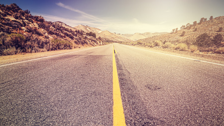 Retro vintage old film style endless country road, travel adventure concept, space for text, USA.の写真素材
