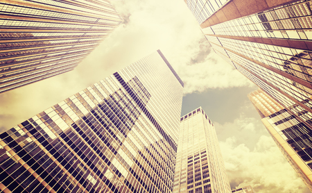 Retro stylized photo of skyscrapers in Manhattan at sunset, New York City, USA.の写真素材