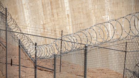 Barbed wire fence, shallow depth of field, crime and punishment concept photo.の写真素材