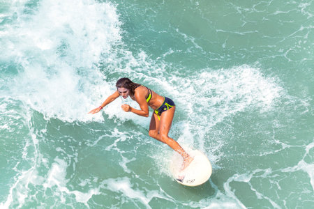 Venice, Los Angeles, USA - August 22, 2015: Young woman surfing at Venice Beach on a beautiful sunny day.のeditorial素材