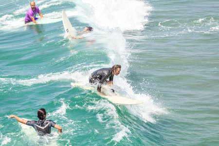 Venice, Los Angeles, USA - August 22, 2015: Gliding surfer among others waiting for waves on a beautiful sunny day.のeditorial素材