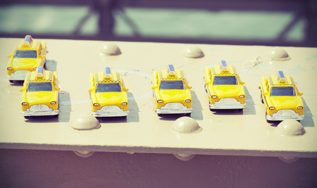 Cross processed photo of taxi toys on Brooklyn Bridge, travel concept.の写真素材