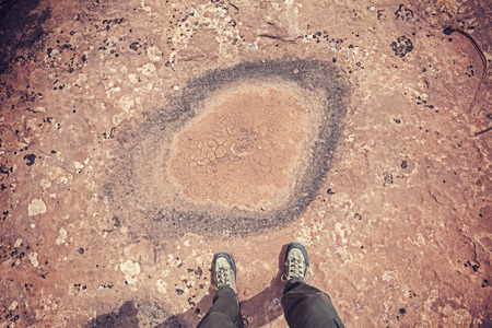 Feet standing in front of dried out puddle, climate change concept.の写真素材