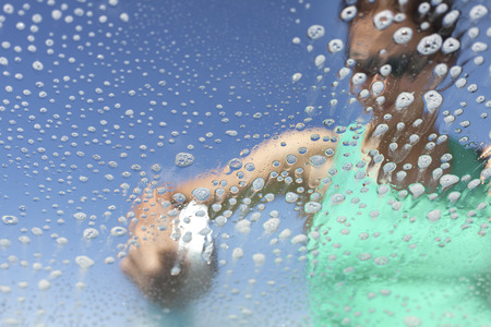 Washing car window, soap bubbles from inside, shallow depth of field.の写真素材