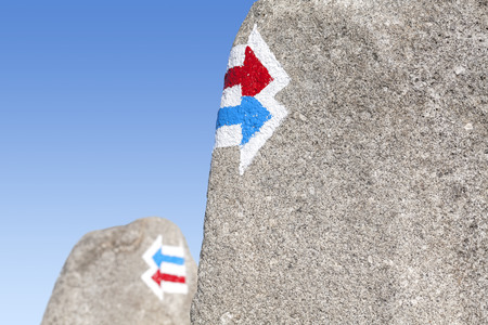 Trail signs painted on rock, choice or dilemma concept.