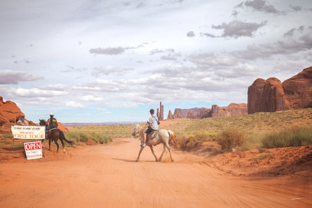 Utah, USA - September 7, 2015: Tourist riding horse in Navajo Nation's Monument Valley Park with a guide, horse is an important aspect of the Navajo culture.のeditorial素材