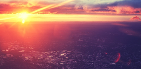 Vintage purple toned dramatic sunset seen from plane with lens flare effect.の写真素材
