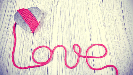 Vintage toned wooden heart with love sign.の写真素材
