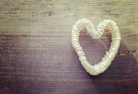 Vintage stylized heart made of shells on wooden background, space for text.の写真素材